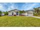 Single-story house with a large front yard, palm trees, and a two-car garage at 7297 Jennifer Dr, Port Charlotte, FL 33981