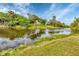 Tranquil waterfront property with lush landscaping and tropical trees at 7297 Jennifer Dr, Port Charlotte, FL 33981