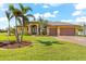 Single-story home with a two-car garage and palm trees at 912 Boundary Blvd, Rotonda West, FL 33947