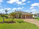 Stunning yellow house with a three-car garage and lush landscaping at 912 Boundary Blvd, Rotonda West, FL 33947