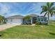 Two-story home with light blue exterior, three-car garage, and palm trees at 9222 Melody Cir, Port Charlotte, FL 33981