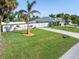 Property features a large grassy yard, a long driveway, and a white fence at 126 Spur Dr, Rotonda West, FL 33947