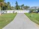 Long driveway leading to a house with a white fence and gate at 126 Spur Dr, Rotonda West, FL 33947