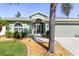 House exterior features a light green facade, palm trees, and a screened-in entryway at 126 Spur Dr, Rotonda West, FL 33947