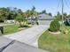 Single-story house with light green exterior, landscaping and palm trees at 126 Spur Dr, Rotonda West, FL 33947