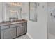 Elegant bathroom with granite countertop, gray cabinets, and a walk-in shower at 14252 Joggins Ave, Port Charlotte, FL 33981