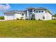 Modern white house with attached garage and lush green lawn at 14252 Joggins Ave, Port Charlotte, FL 33981