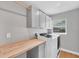 Bright laundry room featuring built-in cabinets and butcher block countertop at 14252 Joggins Ave, Port Charlotte, FL 33981