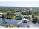 Expansive aerial view of a canal-front home with a private pool and dock in a residential neighborhood at 15448 Melport Cir, Port Charlotte, FL 33981