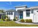 Front entrance with teal door, shutters, and walkway at 15448 Melport Cir, Port Charlotte, FL 33981