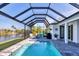 Lush patio with screened enclosure, pool, and canal view at 15448 Melport Cir, Port Charlotte, FL 33981