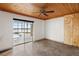 Simple bedroom with wood ceiling, sliding glass doors, and concrete floors at 1990-B Bayshore Dr, Englewood, FL 34223