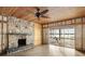 Spacious living area with stone fireplace and sliding glass doors at 1990-B Bayshore Dr, Englewood, FL 34223