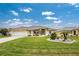 Front yard view of a single story house with a well maintained lawn at 233 Marker Rd, Rotonda West, FL 33947