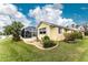 House exterior showcasing a yellow single-story home with a landscaped yard and pool at 233 Marker Rd, Rotonda West, FL 33947