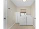 Bright laundry room with washer, dryer, and storage cabinet at 233 Marker Rd, Rotonda West, FL 33947