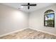 Bright bedroom with wood-look floors and ceiling fan at 26866 Weiskopf Dr, Englewood, FL 34223