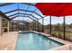 Relaxing pool and spa with a screened enclosure and outdoor kitchen at 26866 Weiskopf Dr, Englewood, FL 34223