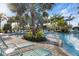 Relaxing pool area with lounge chairs and tropical landscaping at 26866 Weiskopf Dr, Englewood, FL 34223