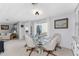 Bright dining area with glass table and four chairs, offering a view into the living room at 3302 Bluejay Ln, Englewood, FL 34224