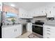 Modern kitchen with stainless steel appliances and white cabinets at 3302 Bluejay Ln, Englewood, FL 34224