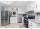 Modern kitchen with stainless steel appliances and white cabinets at 3302 Bluejay Ln, Englewood, FL 34224