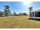 Large grassy backyard with palm trees and a screened patio at 3460 Lullaby Rd, North Port, FL 34287