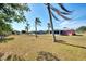 Backyard with grassy area, palm trees, and a partially visible house at 3460 Lullaby Rd, North Port, FL 34287