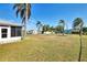 Large backyard with grassy area, palm trees, and screened enclosure at 3460 Lullaby Rd, North Port, FL 34287