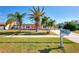 Pink house with palm trees and a well-maintained lawn at 3460 Lullaby Rd, North Port, FL 34287