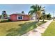 Side view of a pink house with palm trees and a grassy yard at 3460 Lullaby Rd, North Port, FL 34287