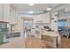 View of kitchen with white cabinets, breakfast bar, and view to living room at 735 Summersea Ct, Englewood, FL 34223