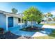 Front view of the house with a blue door and landscaping at 7379 Rosemont Dr, Englewood, FL 34224