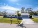 Single-story home with gray exterior, palm trees, and driveway at 7379 Rosemont Dr, Englewood, FL 34224