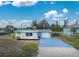 Single-story home with light blue exterior, metal roof, and spacious driveway at 850 E 2Nd St, Englewood, FL 34223