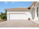 Attached two-car garage with white doors and landscaping at 110 Barracuda Dr, Placida, FL 33946