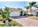 House exterior featuring a brick driveway and palm trees at 11479 Blackfin St, Venice, FL 34292