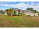 Tan house with palm trees and grassy yard at 1171 Yarmouth St, Port Charlotte, FL 33952