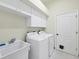 Laundry room with washer, dryer, cabinets, and utility sink at 1171 Yarmouth St, Port Charlotte, FL 33952