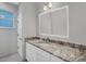 Modern bathroom with granite countertop and a large mirror at 119 White Pine Dr, Rotonda West, FL 33947