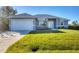 Newly constructed home with gray exterior, two-car garage, and well-manicured lawn at 119 White Pine Dr, Rotonda West, FL 33947