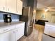 Kitchen with white cabinets, stainless steel fridge, and view of living area at 13278 Carter Ave, Port Charlotte, FL 33981