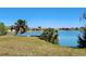 Peaceful lakefront property with lush grass and palm trees at 13278 Carter Ave, Port Charlotte, FL 33981