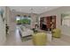 Living room with white couch, green armchairs, and large windows at 13376 Creekside Ln, Port Charlotte, FL 33953