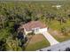 Single-story house with brown roof, driveway, and lush green surroundings at 13478 Carrie Ave, Port Charlotte, FL 33953