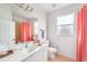 Bathroom with coral shower curtain and white vanity at 13478 Carrie Ave, Port Charlotte, FL 33953