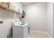 Bright laundry room with washer, dryer, and shelving for storage at 13478 Carrie Ave, Port Charlotte, FL 33953