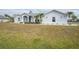 Single-story home with light gray exterior, palm trees, and manicured lawn at 142 Broadmoor Ln, Rotonda West, FL 33947