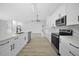 Modern kitchen with white cabinets, a large island, and stainless steel appliances at 142 Broadmoor Ln, Rotonda West, FL 33947