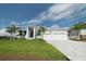 White two-story house with a three-car garage, and lush landscaping at 159 Colony Point Dr, Punta Gorda, FL 33950